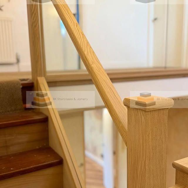 Staircase with glass balustrade and light wood handrail