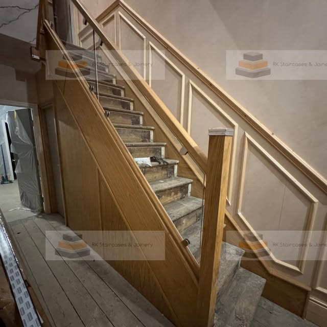 Modern bannister with natural wood handrails undergoing renovation
