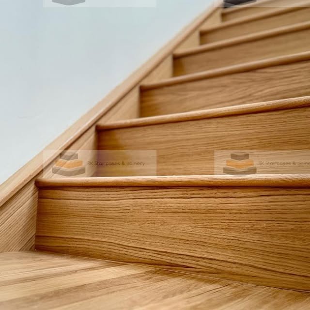 Geometric black metal balustrade with oak handrail by RK Staircases