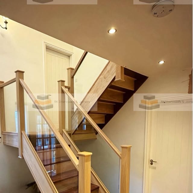 Light-colored wooden staircase with glass balustrades