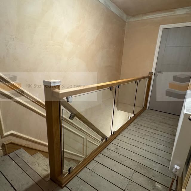 Modern landing with oak railing and glass panels